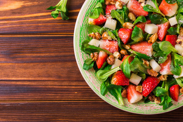 Salad with strawberry, spinach, walnuts and goat cheese