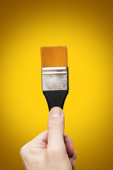 Male hand holding a flat tip paint brush, clipping paths included