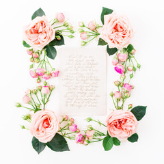 Floral frame with pink roses and paper card with calligraphic quote on white background. Flat lay, top view. Frame background