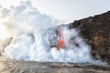 Fototapeta na wymiar Explosion of ash and debris at Kamokuna entry Hawaii as fire hose of lava pours into ocean