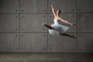 Ballerina in white dress doing Grand pas de sha (big cat's jump) (focus is on the dress)
