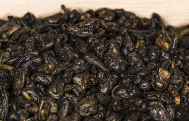 Dry leaves of black tea on wooden board 