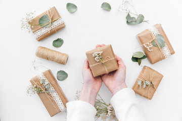 Overhead view of a Woman's cupped hands holding wrapped Christmas gifts