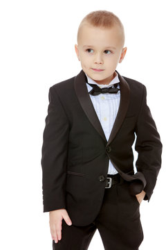 Trendy little boy in a black suit with a tie.