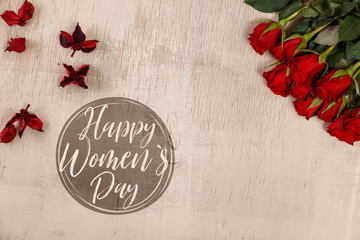 Red roses on wood vintage background. Happy womens day. Concept for romantic love design. Fresh natural flowers. Wooden grunge board.