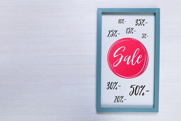 Blank photo frame on white wood background. Sale discounts design. Painted scraped wooden planks texture or pattern.