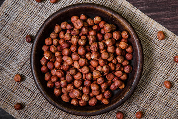 Hazelnut in bowl. Peeled nuts. Organic food on rustic wooden table with sackcloth. Top view.