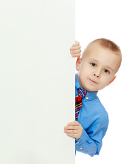 boy peeks out from behind the banner