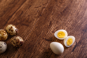 Fototapeta na wymiar Quail eggs. Raw and boiled sliced food. Natural organic eco eggs. Wooden rustic background.