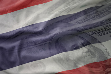 colorful waving national flag of thailand on a american dollar money background. finance concept