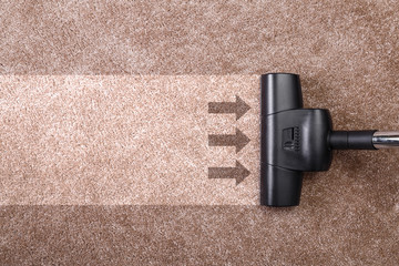 Vacuuming carpet with vacuum cleaner. Housework service. Close up of the head of a sweeper cleaning...