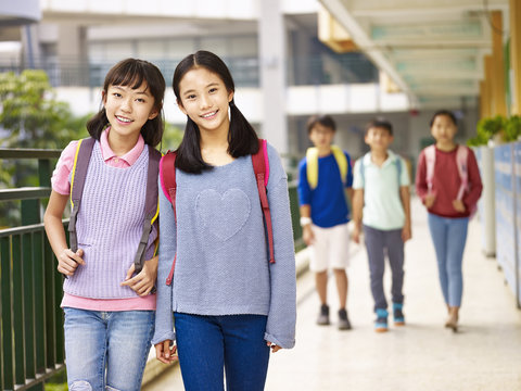 asian elementary school girls walking in the hallway