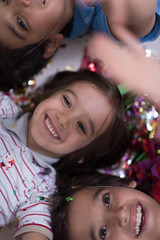 kids  blowing confetti while lying on the floor