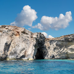 Fototapeta na wymiar Limestone rock caves and blue Mediterranean water of Comino island