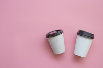 Flat lay design of 2 hot coffee cups on pink pastel background. with copy space.