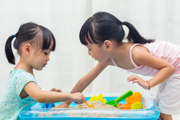 Asian Chinese little girls playing kinetic sand at home