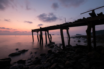 Sunset at pier on rock beach in Koh Chang, Thailand