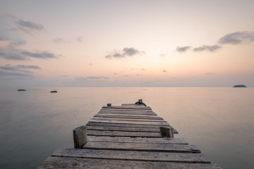 Sunset at pier on rock beach in Koh Chang, Thailand