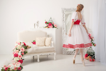 A sweet ballerina in a stage suit in front of a mirror. Retro dress.