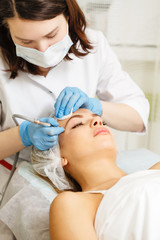 Dermabrasion temples girl. Hardware cosmetology. Spa. Facial Rejuvenation. Mechanical peeling skin.