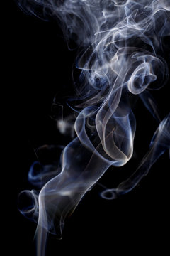 Abstract art. Color white blue smoke from the aromatic sticks on a black background. Background for Halloween. Texture fog. Design element. The concept of aromatherapy.