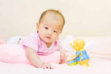 Fototapeta na wymiar Cute adorable newborn baby playing on colorful toy