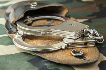 handcuffs on camouflage fabric background - 140729491