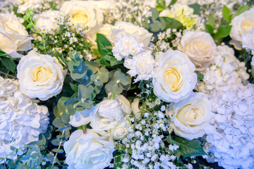 Bunch of flowers : Artificial flowers background. Beautiful flowers background for wedding scene backdrop. flowers and petals background. flower in soft focus image with light on top of the backdrop.