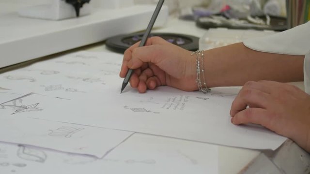 Jewelry designer s hand sketching out designs in studio