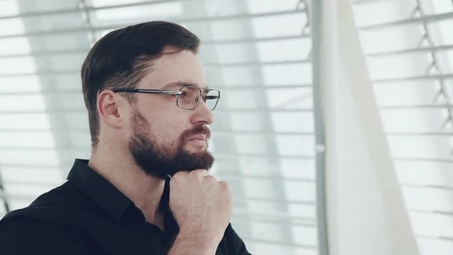 Young businessman looking out of window