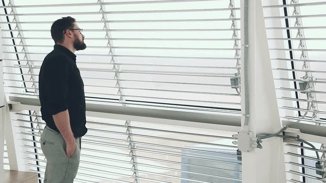 Young businessman looking out of window