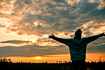 Fototapeta premium Romantic girl walking in a field in sunset light. Winter, autumn life 