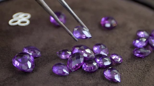 Gems being held by a tweezer on the desk