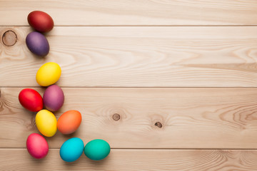 wooden boards and a bunch of colorful Easter eggs in the left corner © kosmos111
