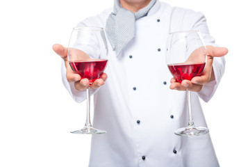 two glasses of wine for guests in the close-up hands of a chef on a white background