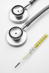 Stethoscope and medical mercury thermometer isolated on white background take with selective color...