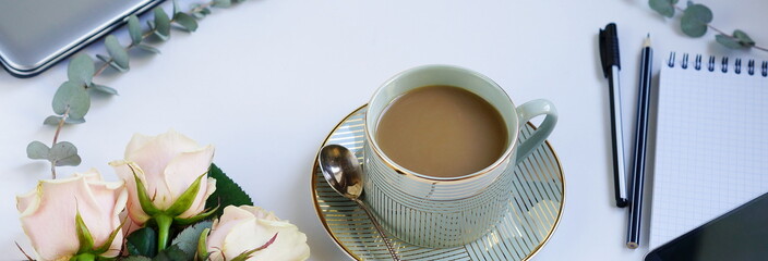 Flat lay, top view office table feminine desk. workspace with laptop, cup of cofee and bouquet pink...