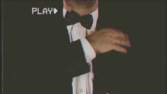 Fake VHS tape: a well-dressed man adjusting his bow-tie.
