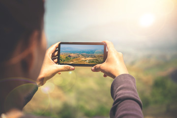 Woman hand using mobile phone photo. Mountain nature