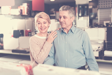 Mature couple are visiting shop of household appliances for buyi