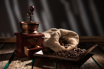 Coffee mill on dark rustic background. Wood table