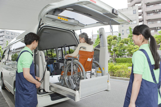Senior Woman Entering Van, Two Nurses Watching