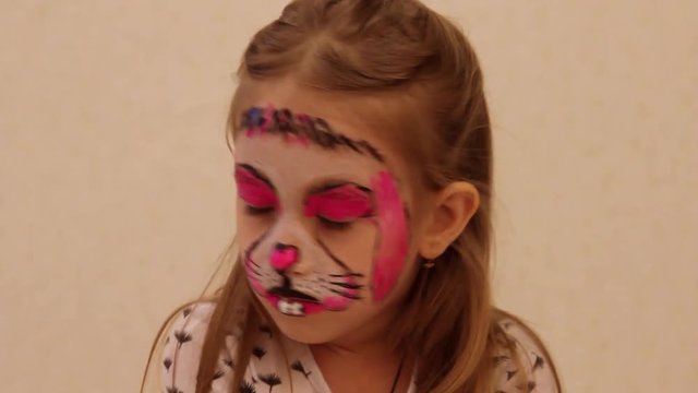 little girl with faceart on birthday party in process close up