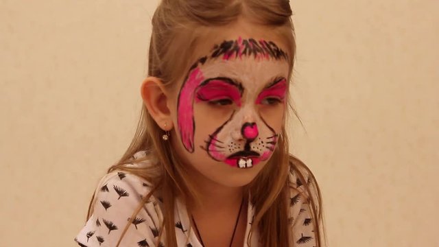 little girl with faceart on birthday party in process close up