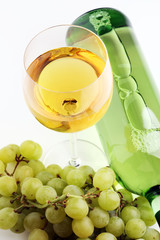 Bottle of white wine, grape on wooden table