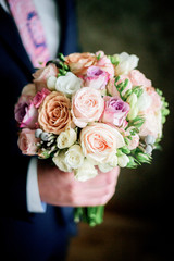 Tender wedding bouquet made of pink roses held by groom