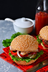 Homemade hamburger with beef, tomatoes and lettuce on a concrete background. Fast food.