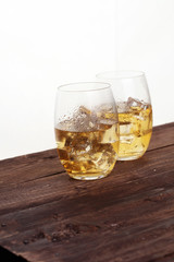 glass of whiskey with ice on a wooden