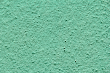 Building wall plastered with plaster painted blue green