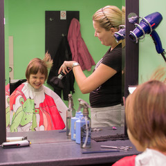 Child dries the hair in a hair salon